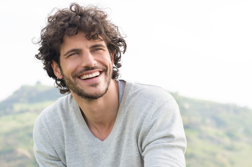 A man smiling while outdoors - Dental Crowns Columbus