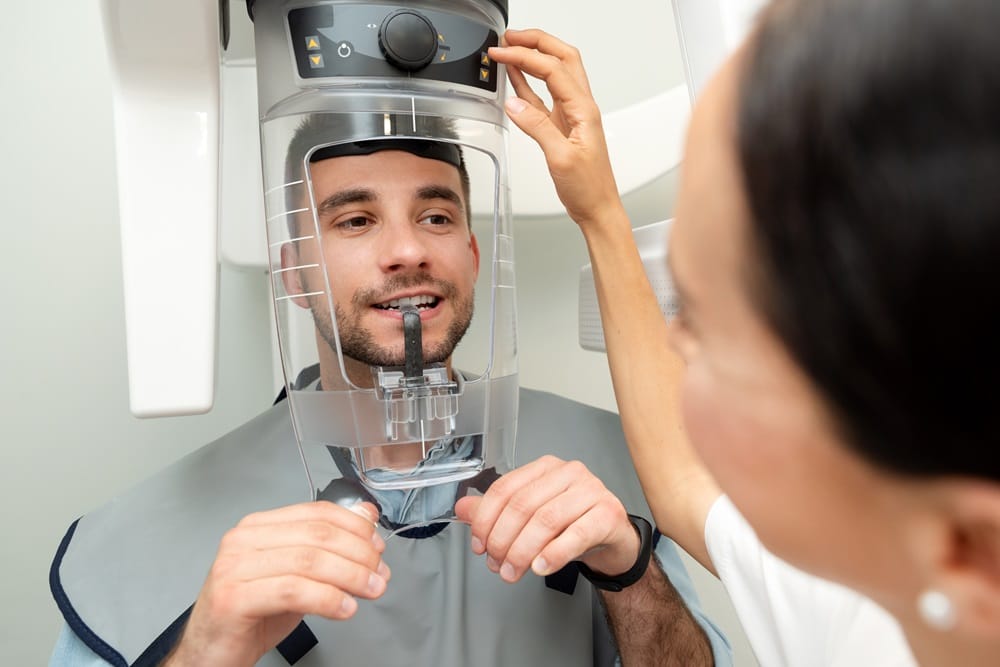 A man preparing for a dental X-ray scan with assistance from a dental technician - Dentist Columbus Ohio​​